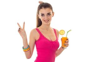 beautiful young girl in a bright pink shirt smiling keeps the juice and hand gesture photo