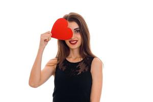 charming girl in black dress smiles and keeps the ball red heart near your eyes photo