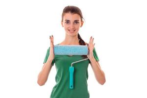 young cutie woman with dark hair in uniforl makes renovations with paint roller in her hands isolated on white background photo