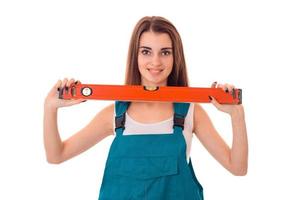 young cheerful woman with dark hair in uniforl makes renovations with measure tape in her hands isolated on white background photo