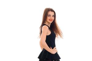 beautiful girl in black dress is worth turning sideways to the camera smiling and keeping her hand on the side photo