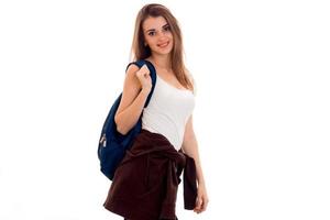 young girl in white shirt and with a rucksack on shoulder smiling and looking at camera photo