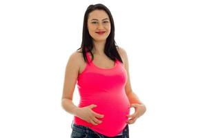 young smiling pregnant woman looks into the camera and smiling photo