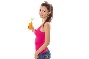 beautiful young girl in a pink shirt smiling stands sideways and keeps the juice photo