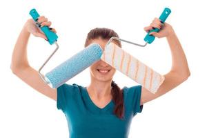 young girl holding rollers for painting closing face and smiling photo