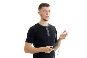 young guy looking seriously into the distance in one hand holds the phone and other hand stretched forward photo