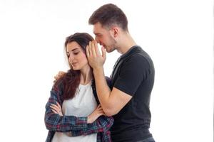 young guy says something to the girl in her ear and she is smiling photo