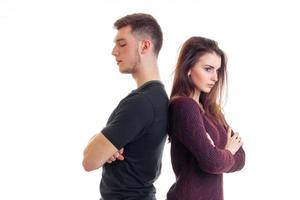 young guy and girl stand backs to each other with folded hands photo