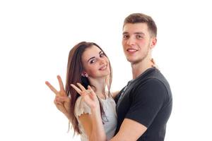 cheerful young couple standing next to each other show a gesture of greetings and smiling photo