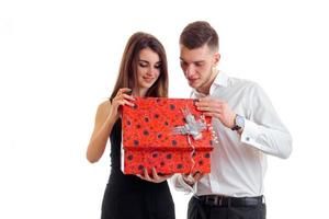 chico y chica hermosa joven miran en caja de regalo foto