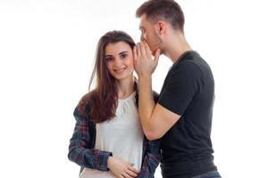 el chico joven le dice algo a la chica en su oído y ella está sonriendo foto