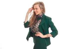 blonde in a green suit stands sideways had put hand on the side photo