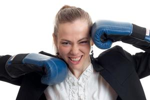 Portrait of sexual young blondes with beautiful smile which looks straight and keeps hands in boxing gloves near the face photo