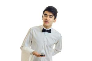 attractive young waiter with a butterfly on his neck and the jacket leaned forward and looks toward photo