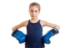 baby-girl standing directly looks into the camera and holds hands in boxing gloves on every close-up photo