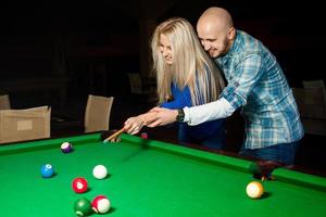 Picture of beauty couple in love plays pool billiard for the first tima and having fun photo