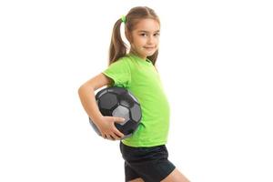 pequeña chica atlética con gigante sosteniendo una pelota foto