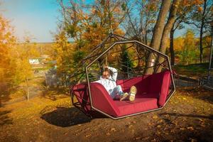 Girl rides on a swing over a cliff photo