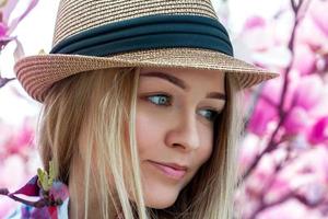 Cutie young blonde woman in hat looking away with flowers photo