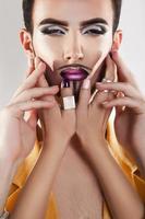 Glamour male model with makeup and four hands photo