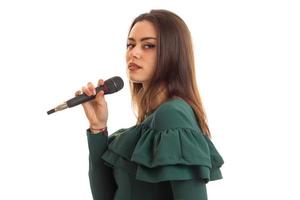 Serious young girl sings a karaoke in microphone photo