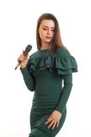 retrato vertical de una atractiva joven cantante vestida y con un micrófono foto