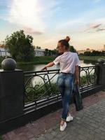 Beautiful girl walks along the riverembankment photo