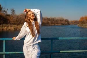 beautiful girl in white clothes stands on the bridge photo