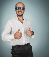 Fun man in sunglasses and white shirt in studio smiling photo