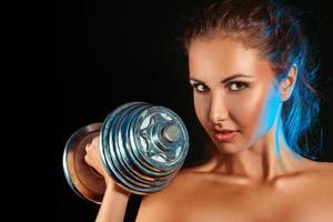 Portrait of girl with dumbbells in hand photo