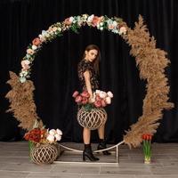 Beautiful woman posing at circle of deadwood in dress with flower print photo