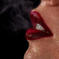 Macro photo of wet woman's lips with smoke on background