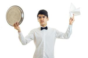 Surprised brunette man waiter with tray and servet in his hands looking at the camera photo