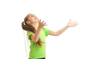 niña divertida en camisa verde atrapando algo foto