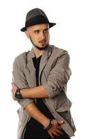 portrait of young handsome unshaved man in hat and jacket looking away photo