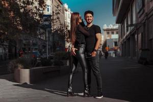 una alegre pareja joven se abraza en la ciudad durante el día foto