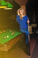 Beddable younge beauty woman posin at pool table photo