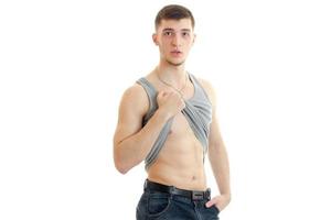 Muscular young man take off his shirt and looking at the camera photo