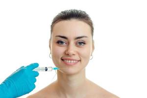 Portrait of young girl smiling close-up with a doctor-cosmetologist who enters her vaccine on face photo