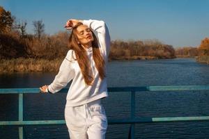 hermosa chica vestida de blanco se encuentra en el puente foto