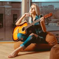 imagen cuadrada chica joven moderna con una guitarra en las manos foto