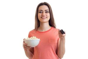 Cute young girl watch a tv and eats a pop-corn photo