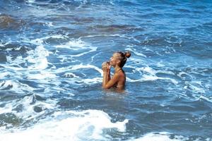 Cute young girl having fun in sea summer time photo