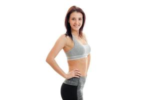 joyful charming young girl stands in the Studio at the sports top and smiling photo