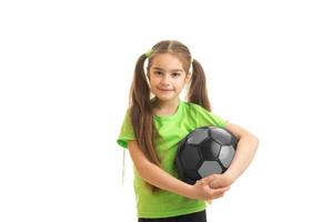 una niña encantadora sosteniendo un balón de fútbol foto