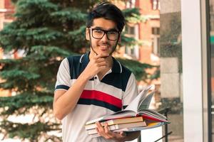 happy glamorous guy in glasses smiles and holds in his hand to book photo