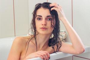 woman with wet hair lies in the bathroom photo