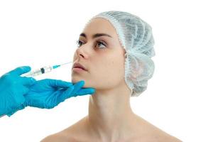 la cosmetóloga presenta una vacuna contra las arrugas en la cara de una niña en un cierre especial de gorra foto