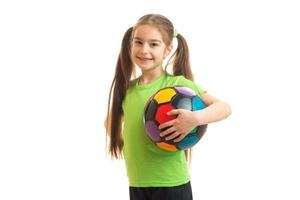 little young girl with soccer ball in hand smiling on camera photo
