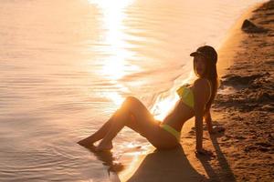 young sexy girl at sunset at the beach photo